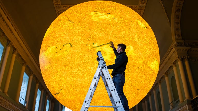 Artist Luke Jerram stands with Helios at Bath Assembly Rooms